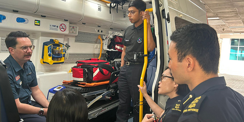 AV6K Medical Director Associate Professor David Anderson speaking to a number of Singapore Civil Defence Force personnel from inside an ambulance during his visit to Singapore in 2023.